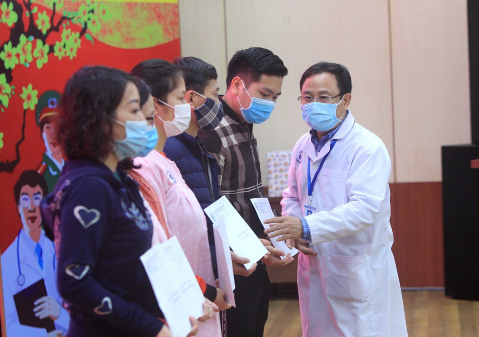 Đại diện gia đình các bệnh nhân nhận giấy chứng nhận ra viện. (Ảnh: An Đăng/TTXVN)