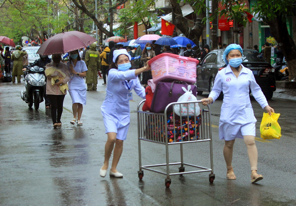 Các bác sỹ giúp bệnh nhân xuất viện ngày sau khi được bệnh viện gỡ bỏ phong tỏa. (Ảnh: An Đăng/TTXVN)