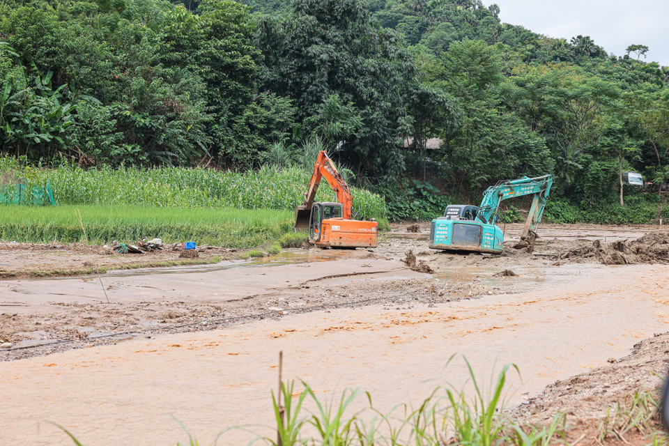 Máy xúc, máy đào được huy động để tìm kiếm tại những vị trí khả năng có nạn nhân. (Ảnh: Hoàng Hiếu/TTXVN)