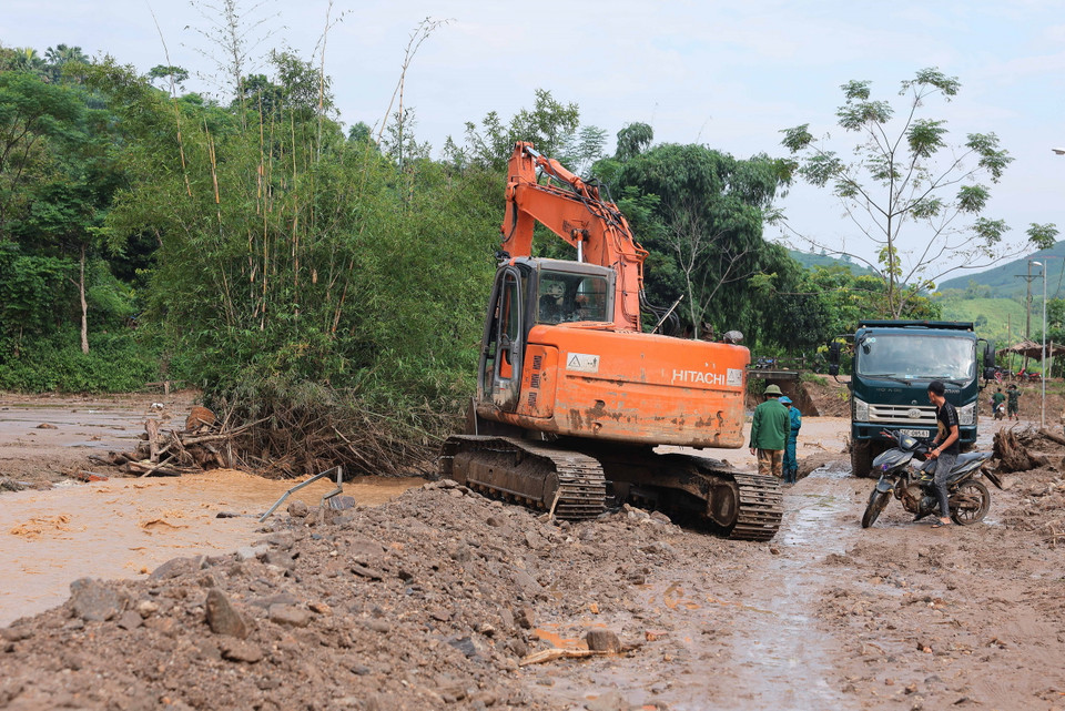 Máy xúc, máy đào được huy động để tìm kiếm tại những vị trí khả năng có nạn nhân. (Ảnh: Hoàng Hiếu/TTXVN)