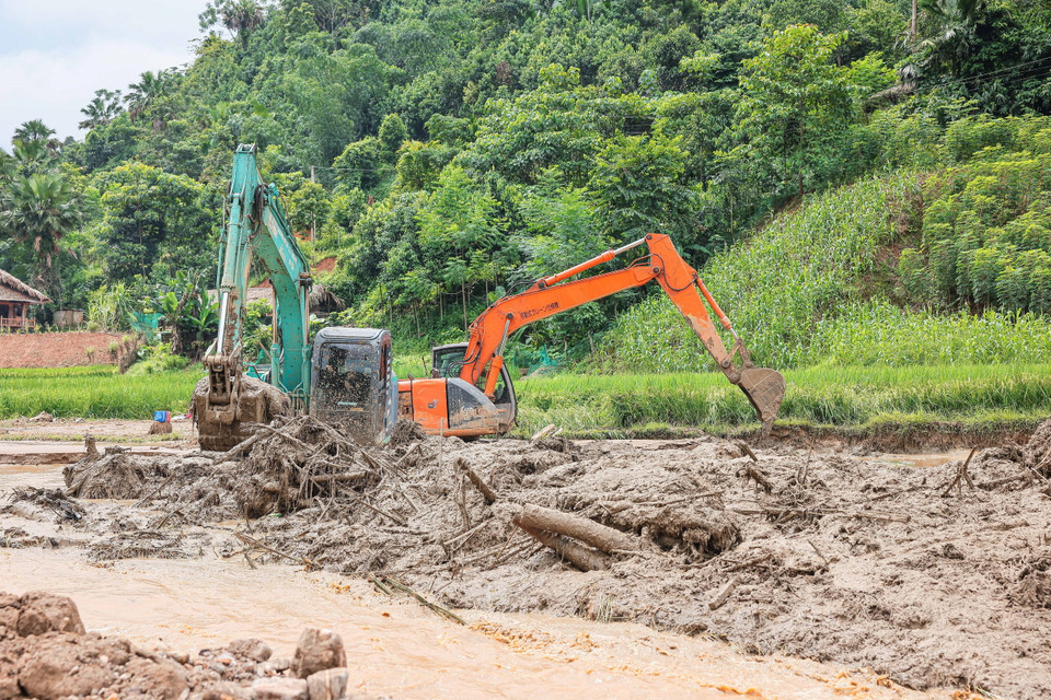 Máy xúc, máy đào được huy động để tìm kiếm tại những vị trí khả năng có nạn nhân. (Ảnh: Hoàng Hiếu/TTXVN)