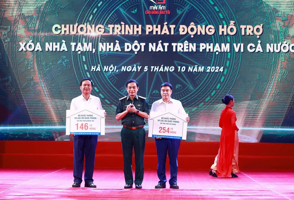 Đại tướng Phan Văn Giang, Bộ trưởng Bộ Quốc phòng trao tượng trưng kinh phí hỗ trợ xóa nhà tạm, nhà dột nát cho đại diện địa phương. (Ảnh: Dương Giang/TTXVN)