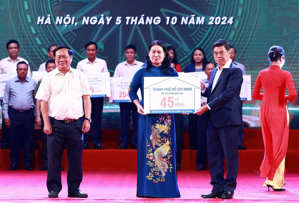 Đại diện lãnh đạo Thành phố Hồ Chí Minh trao tượng trưng kinh phí hỗ trợ xóa nhà tạm, nhà dột nát cho các địa phương. (Ảnh: Dương Giang/TTXVN)