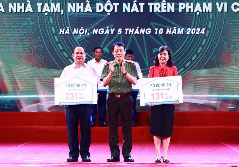 Thượng tướng Lương Tam Quang, Bộ trưởng Bộ Công an trao tượng trưng kinh phí hỗ trợ xóa nhà tạm, nhà dột nát cho đại diện địa phương. (Ảnh: Dương Giang/TTXVN)