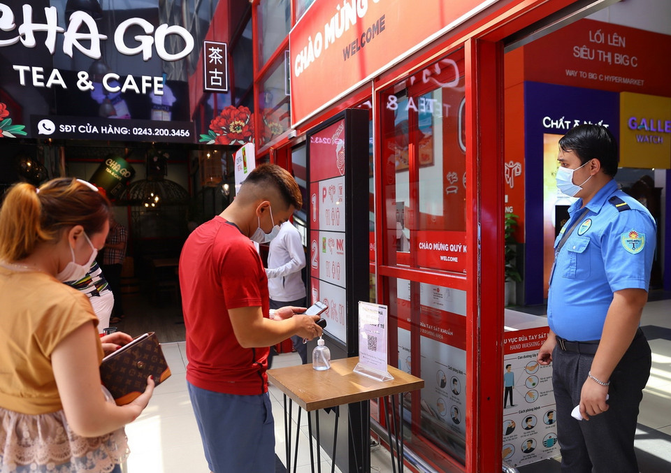  Khách hàng khai báo y tế trực tuyến tại cửa vào trung tâm thương mại BigC Thăng Long trưa 28/9. (Ảnh: Hoàng Hiếu/TTXVN)