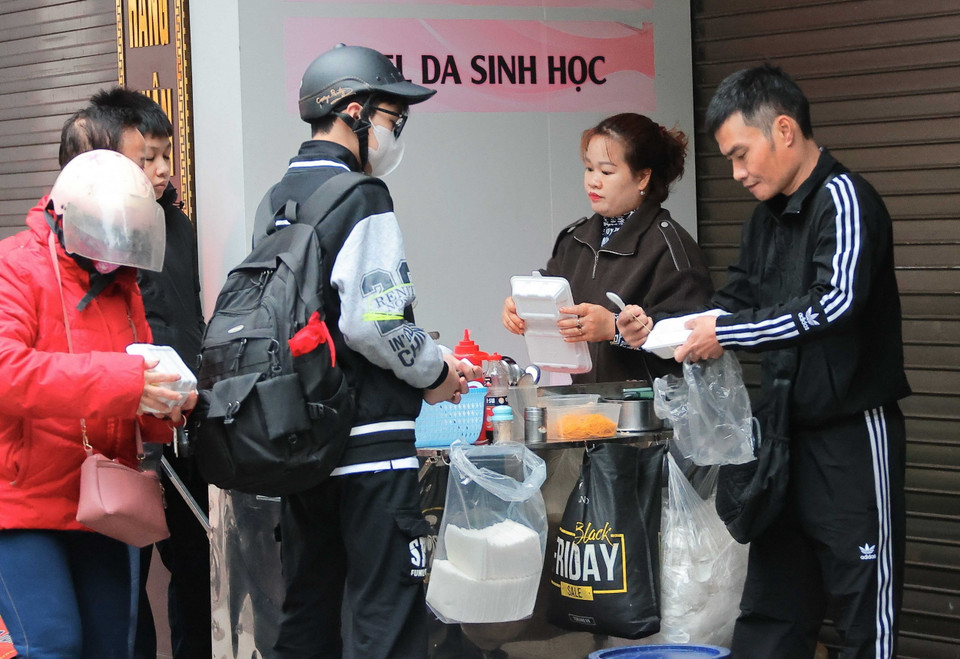 Người lao động, buôn bán ngoài trời thêm vất vả khi nền nhiệt giảm. (Ảnh: Hoàng Hiếu/TTXVN)