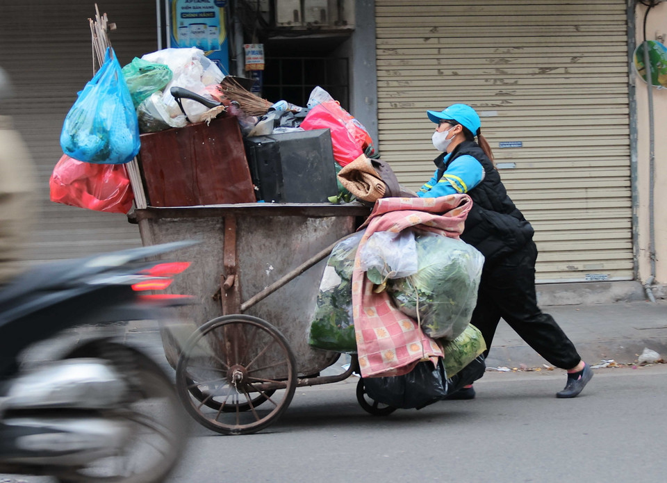 Công nhân môi trường vẫn cần mẫn làm đẹp cho thành phố dù trời rét buốt. (Ảnh: Hoàng Hiếu/TTXVN)
