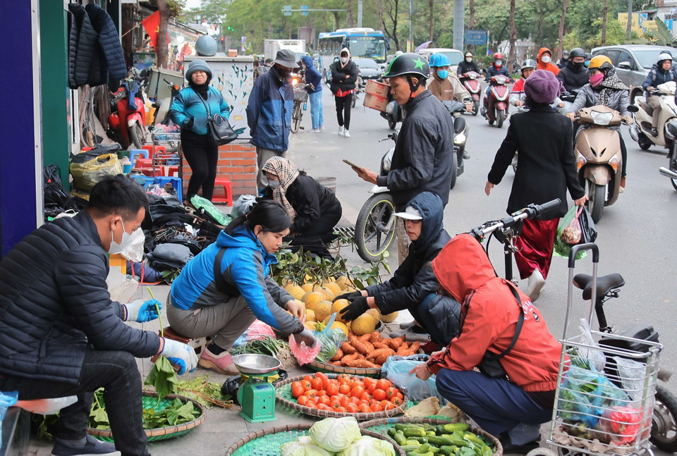 Trời rét đậm khiến công việc buôn bán, mưu sinh của người dân ở ngoài trời thêm nhọc nhằn. (Ảnh: Hoàng Hiếu/TTXVN)