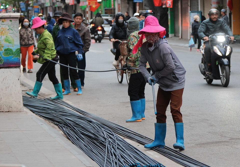 Giá rét khiến công việc của người lao động thêm vất vả. (Ảnh: Hoàng Hiếu/TTXVN)