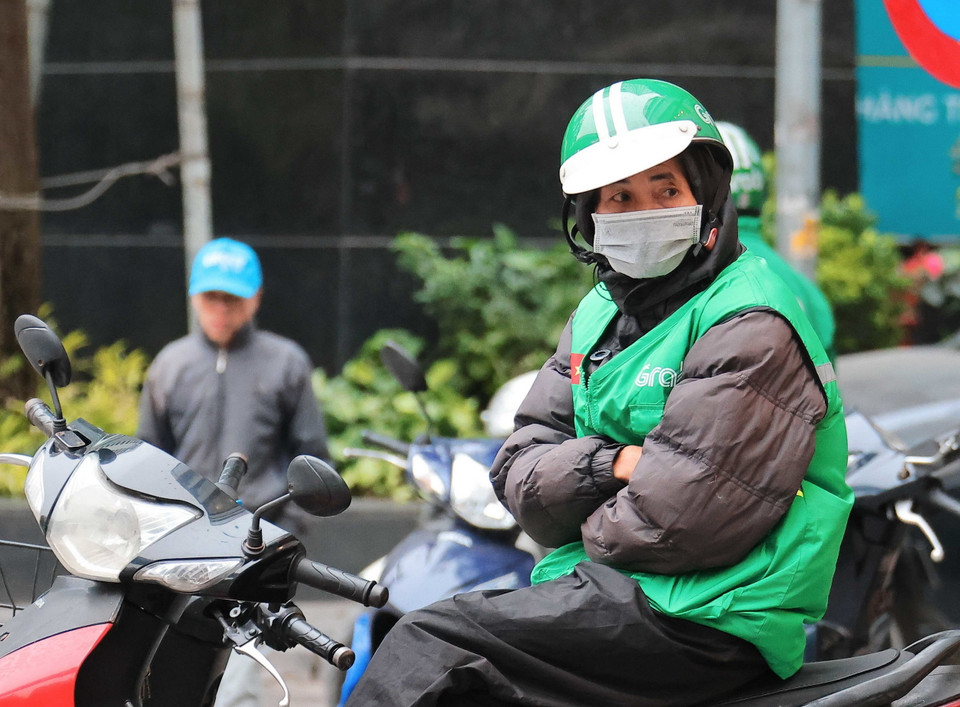 Một lái xe công nghệ co ro chờ khách. (Ảnh: Hoàng Hiếu/TTXVN)