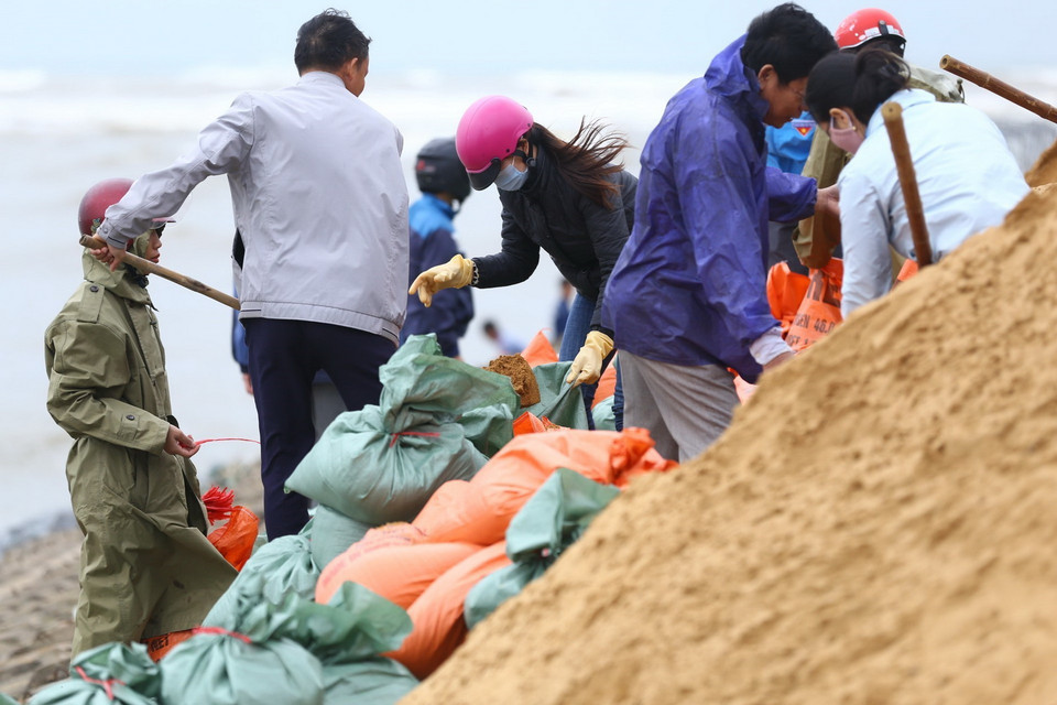 Lực lượng của huyện, xã tích khẩn trương khắc phục điểm sạt lở tại đê biển xã Thịnh Lộc, huyện Lộc Hà. (Ảnh: Minh Quyết/TTXVN)