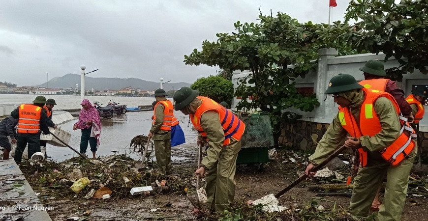Các cán bộ, chiến sỹ dọn dẹp rác thải ứ đọng sau mưa lũ. (Ảnh: TTXVN phát)