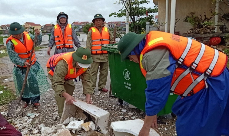Các cán bộ, chiến sỹ dọn dẹp rác thải ứ đọng sau mưa lũ. (Ảnh: TTXVN phát)