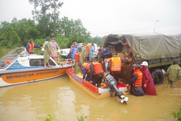 Vận chuyển hàng cứu trợ lên canô để tiếp ứng tận nơi cho người dân. (Ảnh: TTXVN phát)
