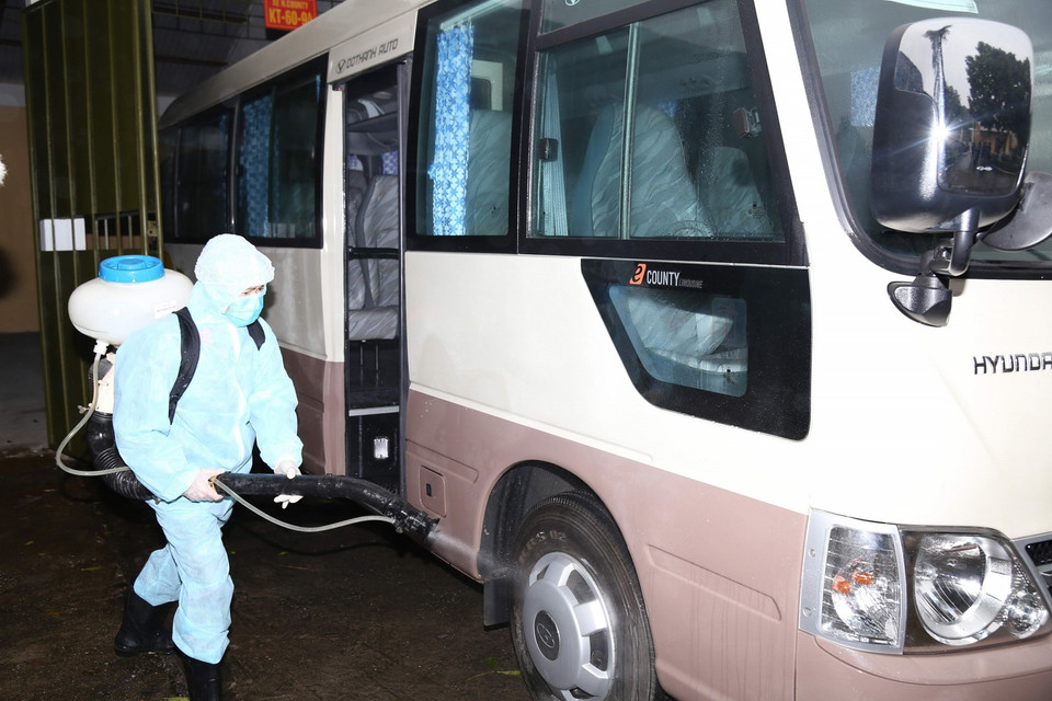 Bộ Tư lệnh Hóa học tiến hành phun hóa chất tiêu tẩy, khử trùng phương tiện đưa đón công dân nhằm ngăn chặn lây lan dịch bệnh. (Ảnh: TTXVN)