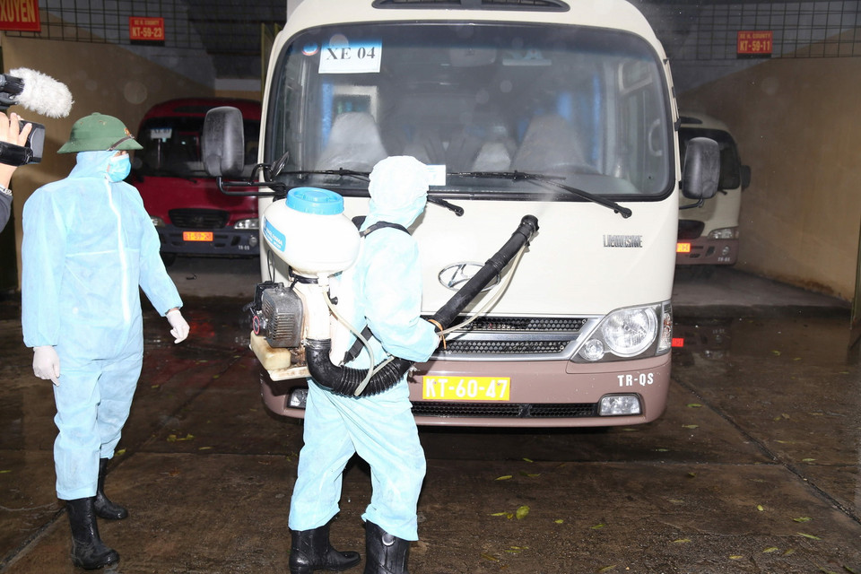Bộ Tư lệnh Hóa học tiến hành phun hóa chất tiêu tẩy, khử trùng phương tiện đưa đón công dân nhằm ngăn chặn lây lan dịch bệnh. (Ảnh: TTXVN)