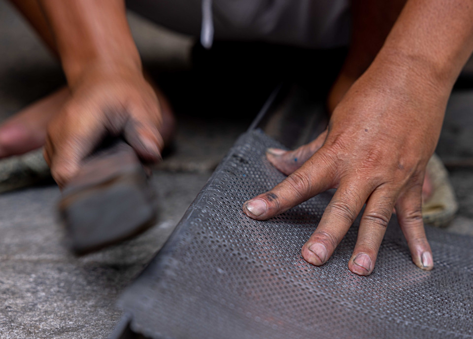 Những người "thợ gõ" vẫn hằng ngày sản xuất, gia công các mặt hàng gia dụng trên phố Hàng Thiếc. (Ảnh: Hoàng Hiếu/TTXVN)