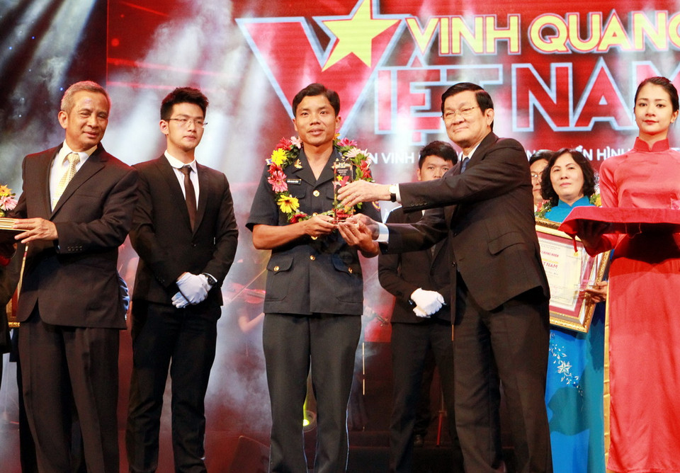 Chủ tịch nước Trương Tấn Sang tặng cúp cho Thượng úy Trần Quang Vững, Chính trị viên tàu cảnh sát biển 4032 có thành tích đặc biệt trong bảo vệ vùng biển Tổ quốc. (Ảnh: Nguyễn Khang/TTXVN)