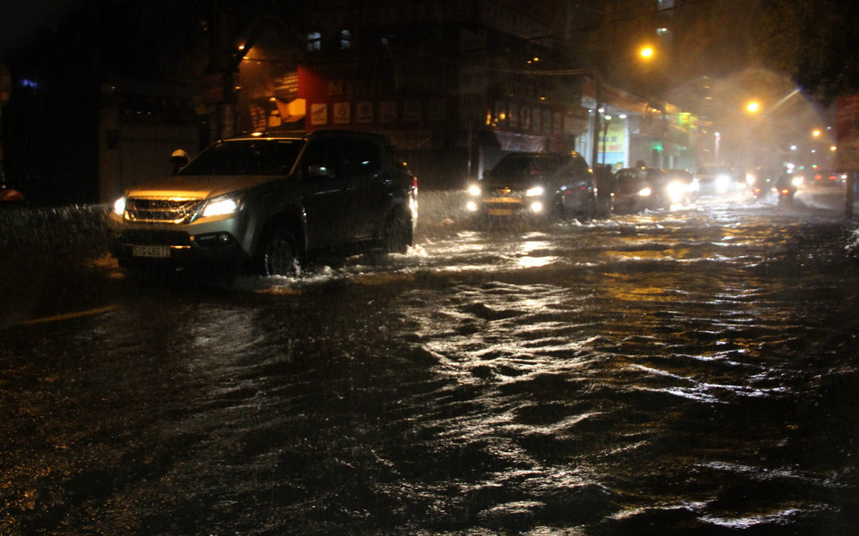 Các phương tiện lưu thông trong tình trạng ngập nước ở đường Lạc Long Quận, quận Tân Bình. (Ảnh: Xuân Dự/TTXVN)