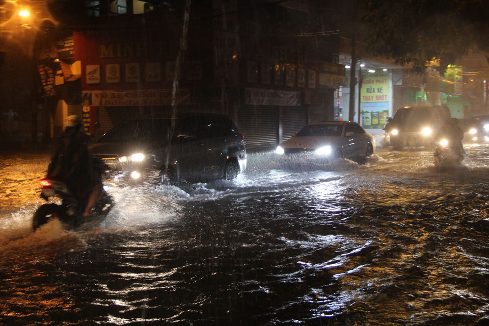 Các phương tiện lưu thông trong tình trạng ngập nước ở đường Lạc Long Quận, quận Tân Bình. (Ảnh: Xuân Dự/TTXVN)