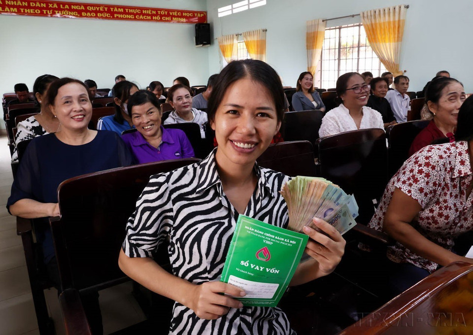 Người dân vui mừng nhận tiền vốn vay từ điểm giao dịch Ngân hàng Chính sách xã hội tỉnh Đồng Nai. (Ảnh: Hồng Đạt/TTXVN)