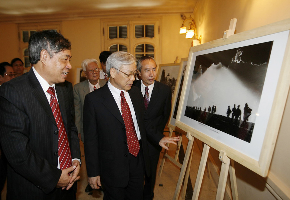 Chủ tịch Quốc hội Nguyễn Phú Trọng xem trưng bày ảnh tại lễ kỷ niệm 65 năm Ngày thành lập Thông tấn xã Việt Nam (15/9/1945 - 15/9/2010) và đón nhận Huân chương Hồ Chí Minh (lần 2), ngày 15/9/2010. (Ảnh: Trí Dũng/TTXVN)