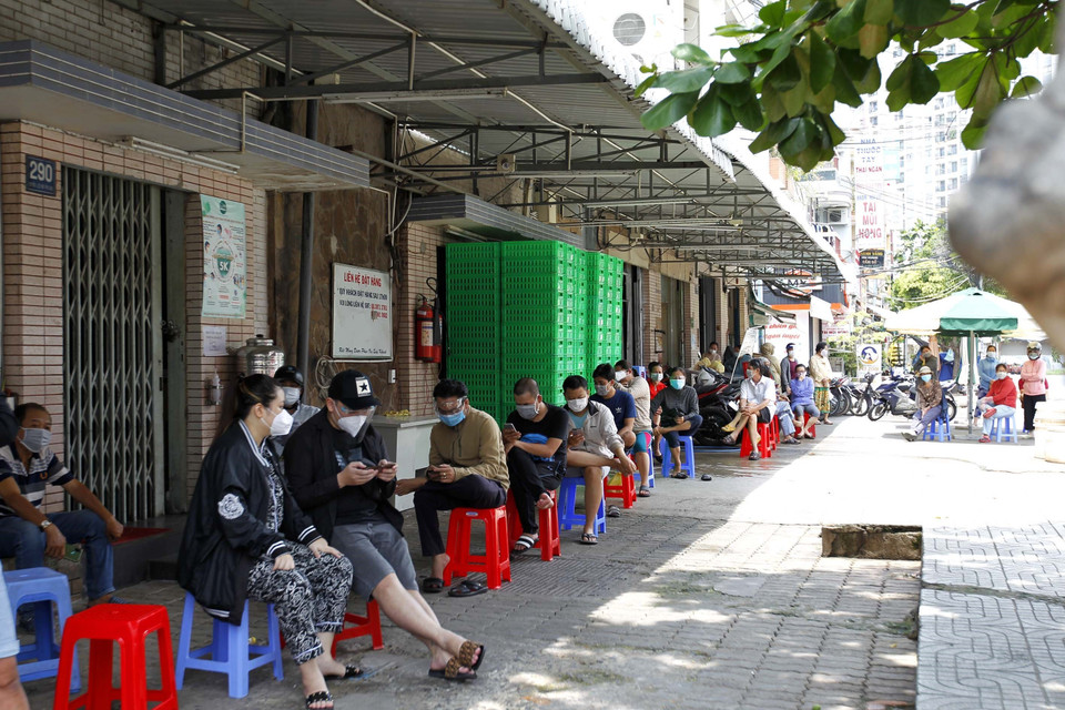 Trước thông tin giãn cách xã hội mới, nhiều người dân Thành phố tranh thủ xếp hàng chờ mua hàng hóa tại cửa hàng San Hà (Quận 8). (Ảnh: Thanh Vũ/TTXVN)