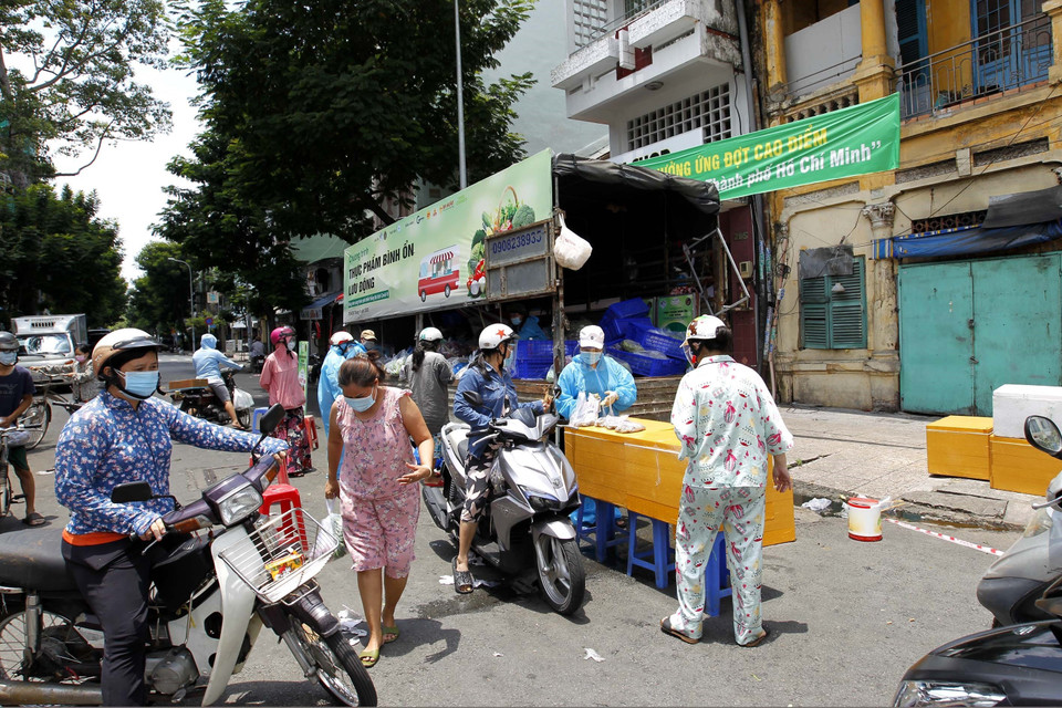 Người dân thành phố tranh thủ mua hàng hóa bình ổn giá trên đường Tháp Mười (Quận 6). (Ảnh: Thanh Vũ/TTXVN)