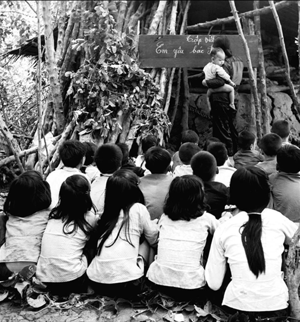 Chị Bảy Tấn, xóm Hào Sai, xã Trần Hợi dạy học văn hóa dã chiến bên cạnh hầm tránh pháo, trong tầm đạn của đồn Cầu Chữ Y, xã Khánh Hưng, tháng 6/1971. (Ảnh: Võ An Khánh/TTXVN)