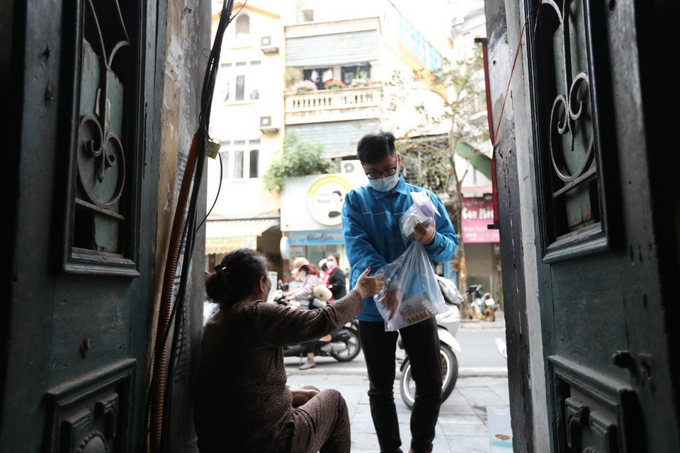 Đoàn viên thanh niên đến phát thuốc cho gia đình có bệnh nhân F0 điều trị tại nhà. Hằng ngày, Bí thư Đoàn phường chịu trách nhiệm báo cáo kết quả công tác lên lãnh đạo phường. (Ảnh: Minh Quyết/TTXVN)