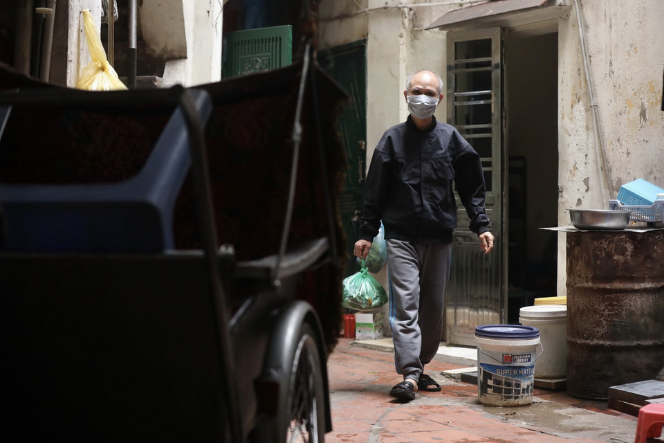 Khi nhận được thông báo về ngày, giờ thu gom rác thải đối với các hộ gia đình có bệnh nhân F0, người dân chấp hành đổ rác, chuyển rác đúng theo quy định. (Ảnh: Minh Quyết/TTXVN)