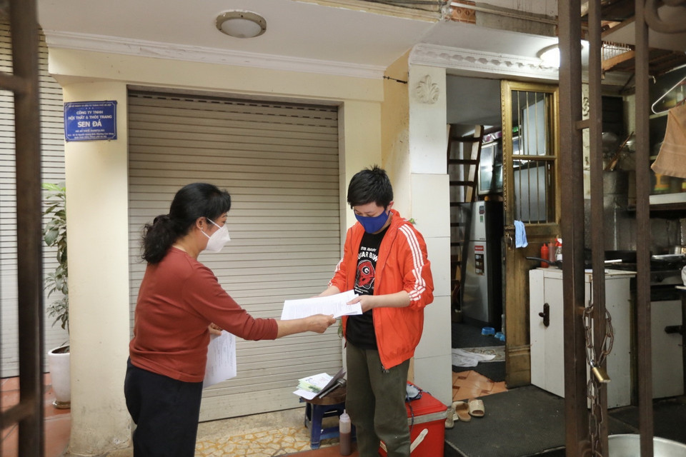 Bà Nguyễn Thị Thanh Hiền, Tổ phó tổ dân phố số 3, phường Cửa Đông đến trạm y tế phường nhận giấy chứng nhận cho các trường hợp F0 đã khỏi bệnh rồi mang đến phát tận nhà cho các bệnh nhân. (Ảnh: Minh Quyết/TTXVN)