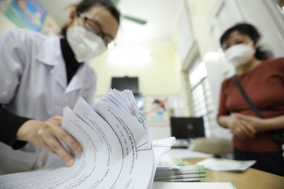 Giấy chứng nhận khỏi bệnh được trạm y tế phường thông báo cho tổ trưởng tổ dân phố đến nhận và phát cho các bệnh nhân F0 khỏi bệnh. (Ảnh: Minh Quyết/TTXVN)