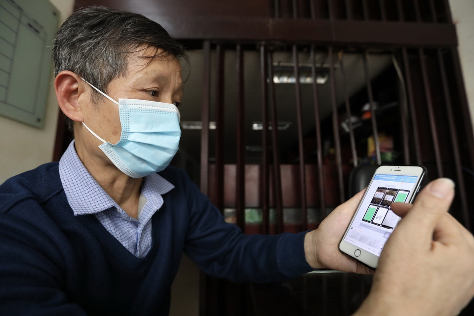 Ông Nguyễn Mạnh Đức, Tổ trưởng tổ dân phố số 7, phường Cửa Đông tiếp nhận thông báo của bệnh nhân F0 qua Zalo ngày 2/3. (Ảnh: Minh Quyết/TTXVN)