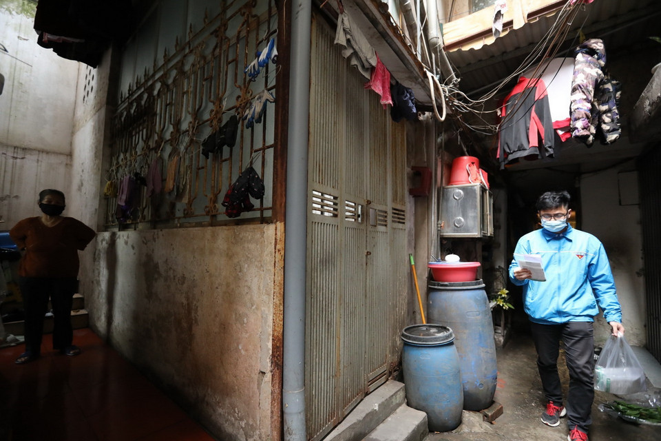 Đoàn viên Nguyễn Viết Long đến phát thuốc cho gia đình có bệnh nhân F0 điều trị tại nhà. (Ảnh: Minh Quyết/TTXVN)