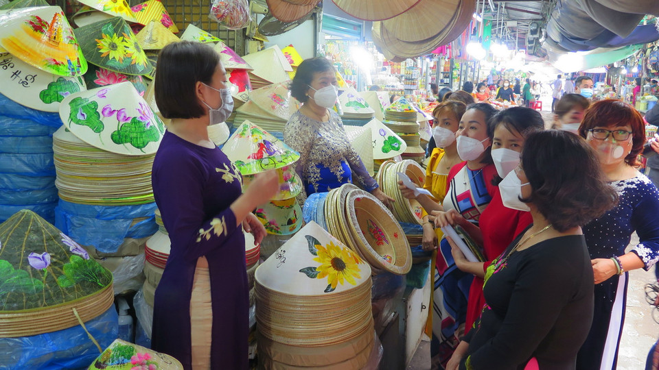 Tiểu thương chợ Đông Ba mặc áo dài nhưng vẫn thực hiện đeo khẩu trang. (Ảnh: Tường Vi/TTXVN)