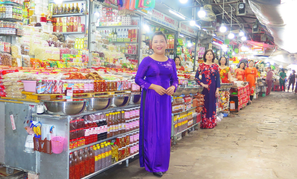 Tiểu thương chợ Đông Ba mặc áo dài buôn bán góp phần làm đẹp hơn hình ảnh ngôi chợ truyền thống hơn 120 tuổi. (Ảnh: Tường Vi/TTXVN)