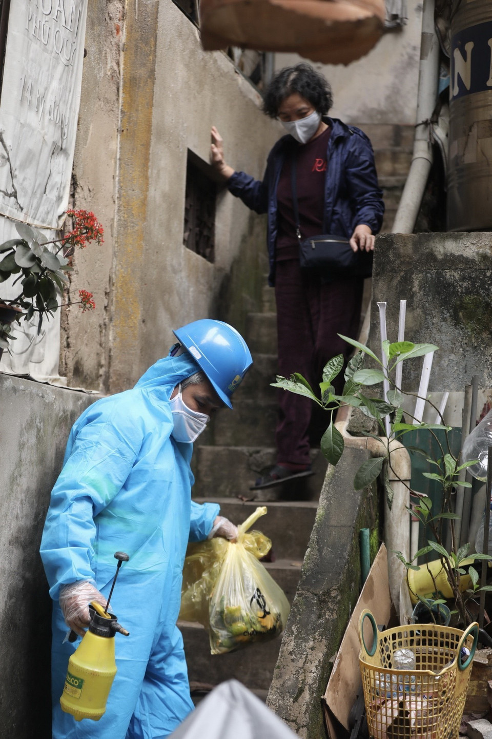 Nhân viên Công ty môi trường đến thu gom rác tại hộ gia đình có bệnh nhân F0. (Ảnh: Minh Quyết/TTXVN)