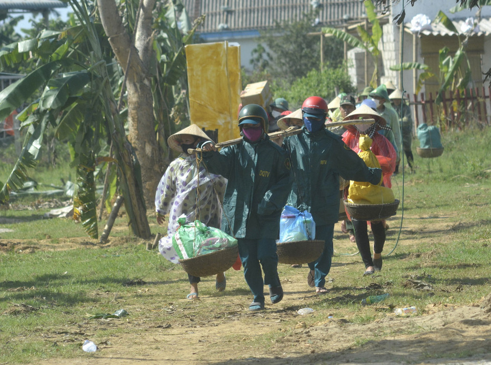 Người dân mang theo nhiều vật dụng di dời để tránh bão đổ bộ, trong tình huống giả định ở buổi diễn tập. (Ảnh: Nguyên Lý/TTXVN)