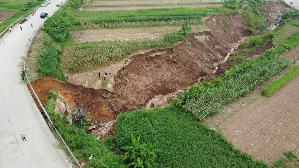 Cống tiêu Ngòi Tre, đoạn Tỉnh lộ 317A bị sạt lở ăn sâu vào lòng đường với chiều dài khoảng 50m, toàn bộ phần tôn hộ lan và các trụ bị đổ gãy, đồng thời ăn sâu vào phía chân đường. (Ảnh: Tạ Toàn/TTXVN)