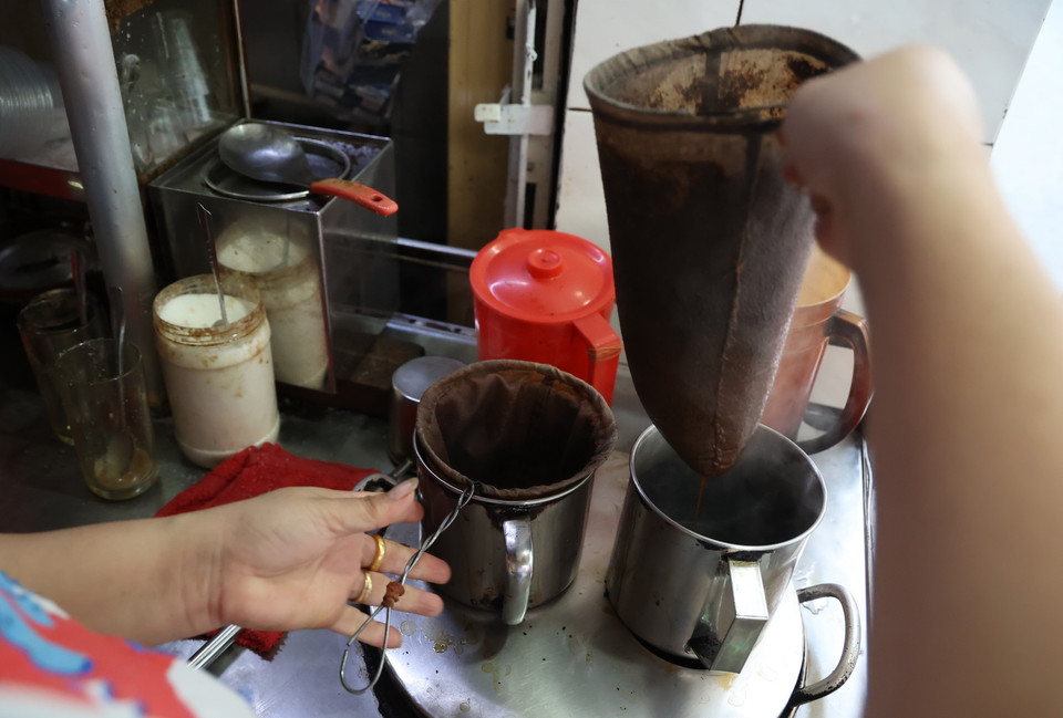 Chủ quán sử dụng 2 chiếc vợt để pha càphê liên tục, đảm bảo có càphê nóng hổi phục vụ khách. (Ảnh: Hồng Đạt/TTXVN)