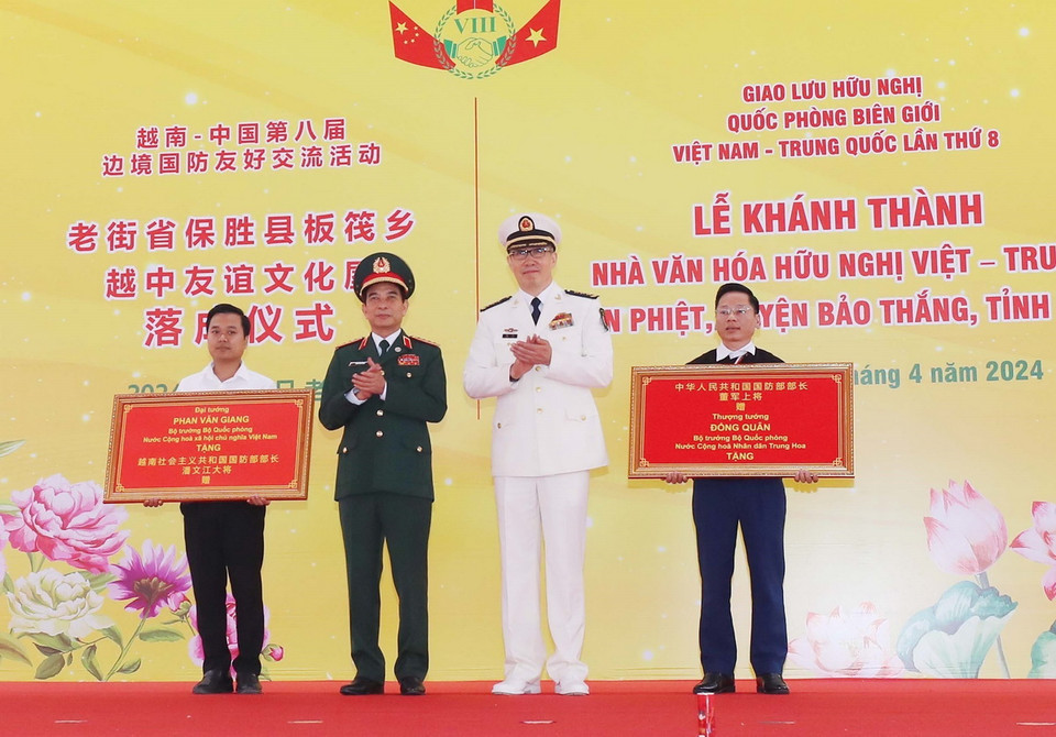 Đại tướng Phan Văn Giang, Bộ trưởng Quốc phòng Việt Nam, và Thượng tướng Đổng Quân, Bộ trưởng Quốc phòng Trung Quốc trao bảng tượng trưng tặng quà cho Nhà văn hóa Hữu nghị Việt Nam-Trung Quốc tại bản Phiệt, huyện Bảo Thắng (Lào Cai). (Ảnh: Trọng Đức/TTXVN)