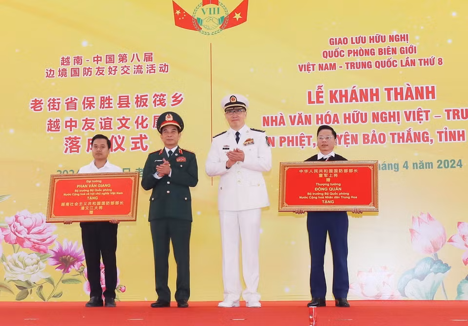 Đại tướng Phan Văn Giang, Bộ trưởng Quốc phòng Việt Nam, và Thượng tướng Đổng Quân, Bộ trưởng Quốc phòng Trung Quốc trao bảng tượng trưng tặng quà cho Nhà văn hóa Hữu nghị Việt Nam-Trung Quốc tại bản Phiệt, huyện Bảo Thắng (Lào Cai). (Ảnh: Trọng Đức/TTXVN)