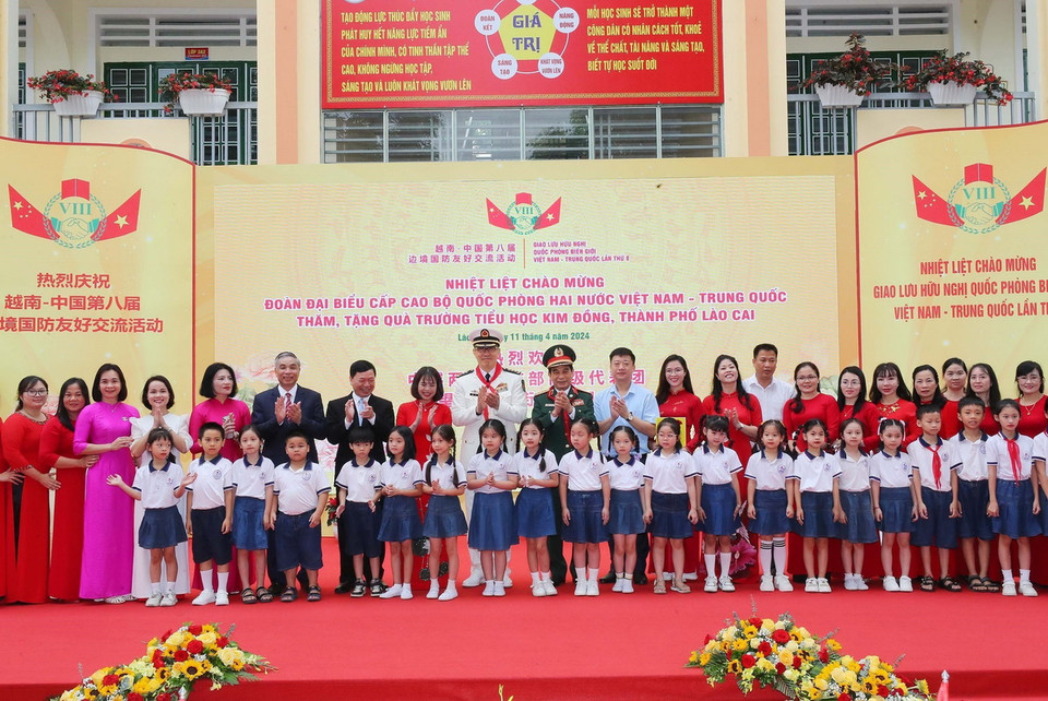 Bộ trưởng Quốc phòng Phan Văn Giang và Bộ trưởng Quốc phòng Trung Quốc Đổng Quân với thầy và trò Trường Tiểu học Kim Đồng (thành phố Lào Cai). (Ảnh: Trọng Đức/TTXVN)
