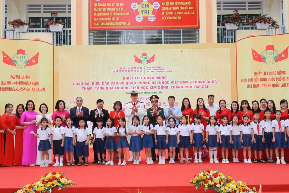 Bộ trưởng Quốc phòng Phan Văn Giang và Bộ trưởng Quốc phòng Trung Quốc Đổng Quân với thầy và trò Trường Tiểu học Kim Đồng (thành phố Lào Cai). (Ảnh: Trọng Đức/TTXVN)