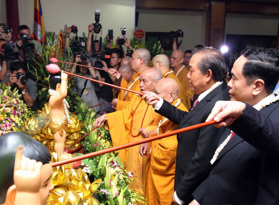 Phó Thủ tướng Trương Hòa Bình, các Hòa thượng, Thượng tọa và các đại biểu thưc hiện nghi Lễ tắm Phật tại Lễ mừng Phật đản. (Ảnh: Nguyễn Dân/TTXVN)