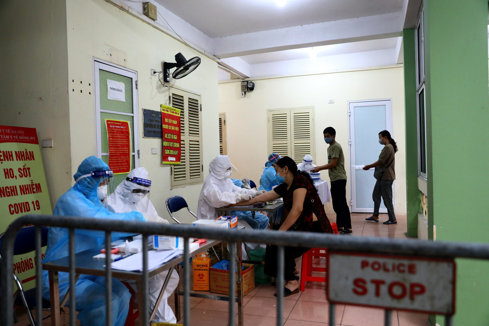 Lấy mẫu máu để xét nghiệm nhanh COVID-19 cho các tiểu thương kinh doanh tại chợ Ngã Tư Sở. (Ảnh: Huy Hùng/TTXVN)