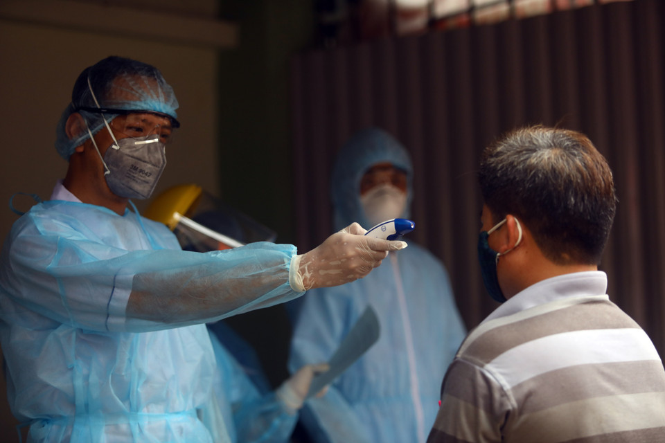  Kiểm tra nhiệt độ trước khi vào lấy mẫu xét nghiệm. (Ảnh: Huy Hùng/TTXVN)