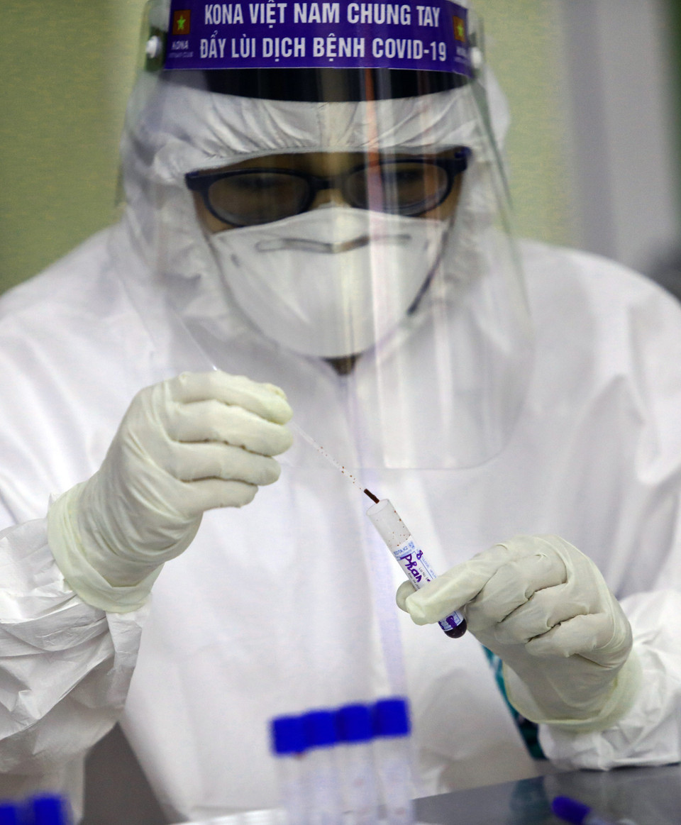 Nhân viên y tế làm test nhanh các mẫu xét nghiệm. (Ảnh: Huy Hùng/TTXVN)