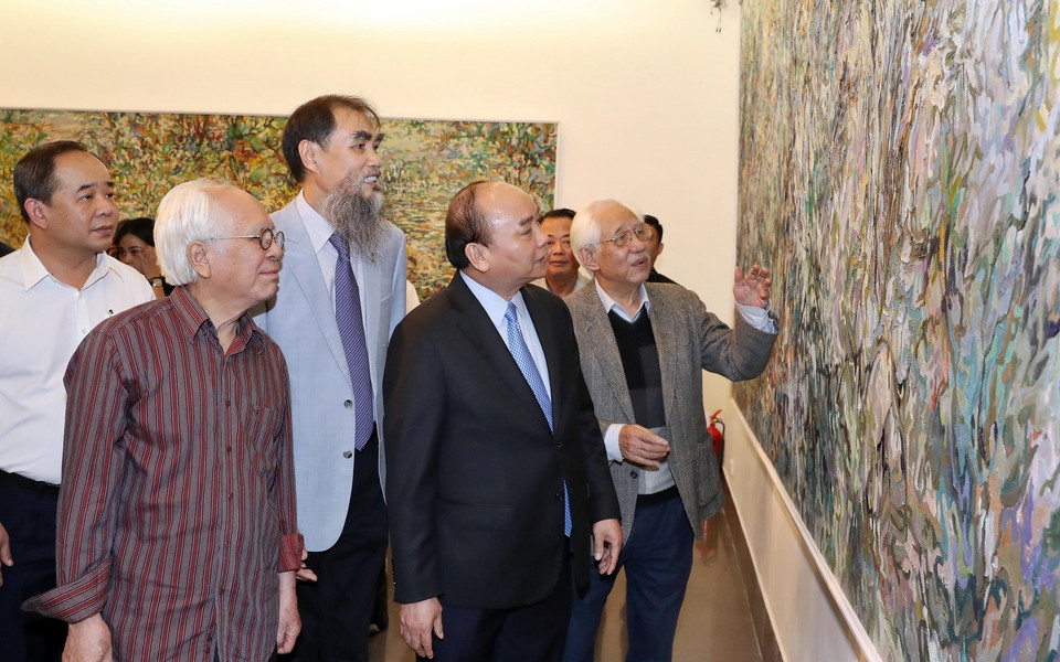 Thủ tướng Nguyễn Xuân Phúc xem bức tranh được trưng bày triển lãm tại Bảo tàng Mỹ thuật Việt Nam. (Ảnh: Thống Nhất/TTXVN)